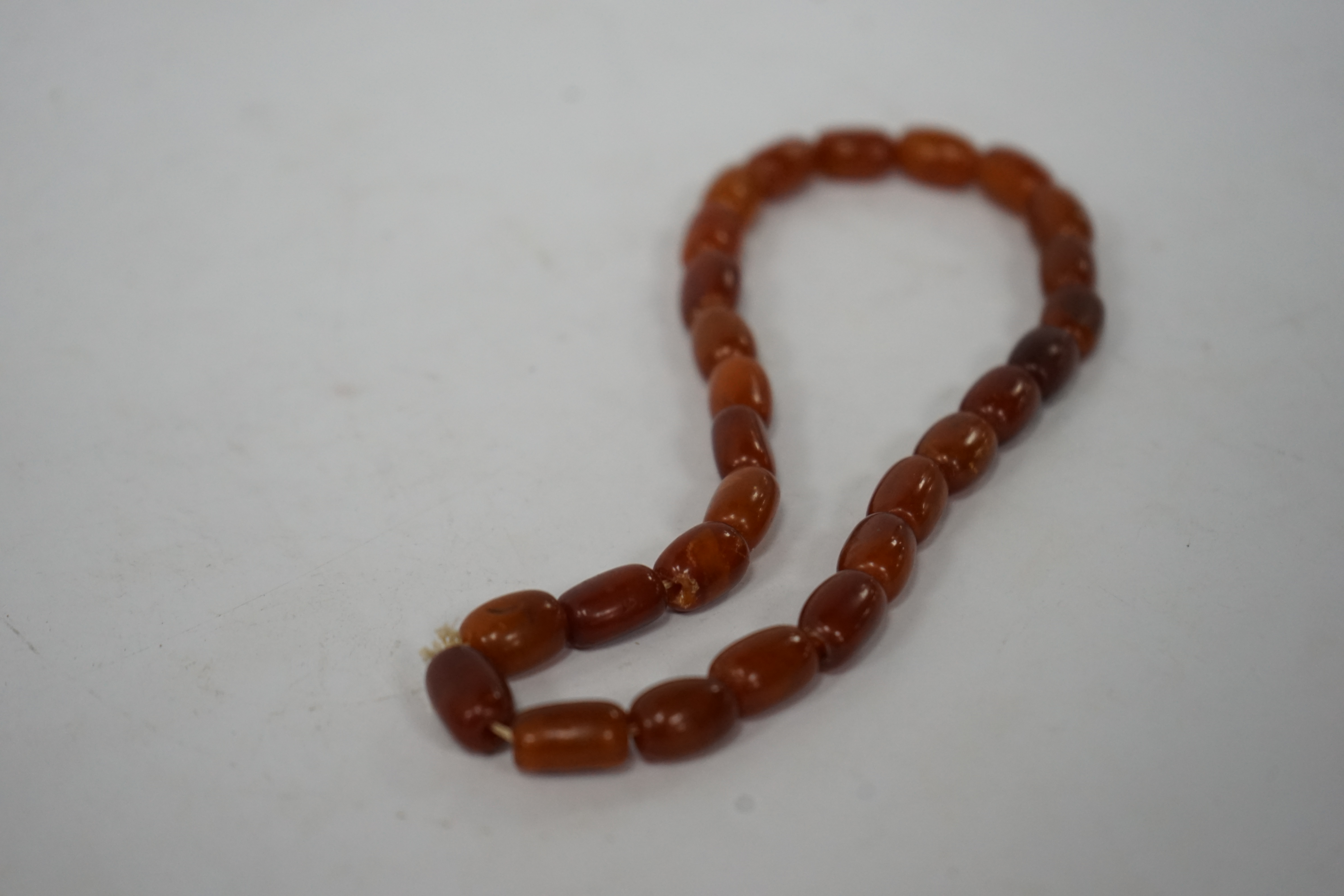 A single strand amber bead necklace, 34cm, gross weight 20 grams. Condition - poor to fair